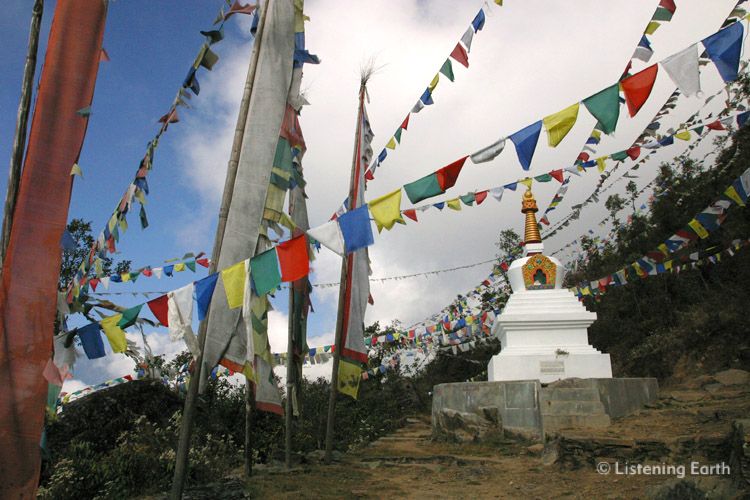 Chorten decorated with prayer flags on the homeward path